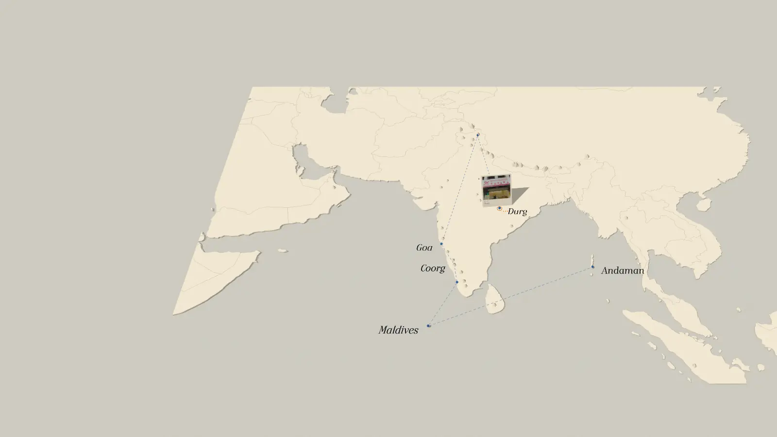 A paper map of India and its neighbours with a blue thread leaving Durg for Ladakh and a postcard of the shop standing at Durg