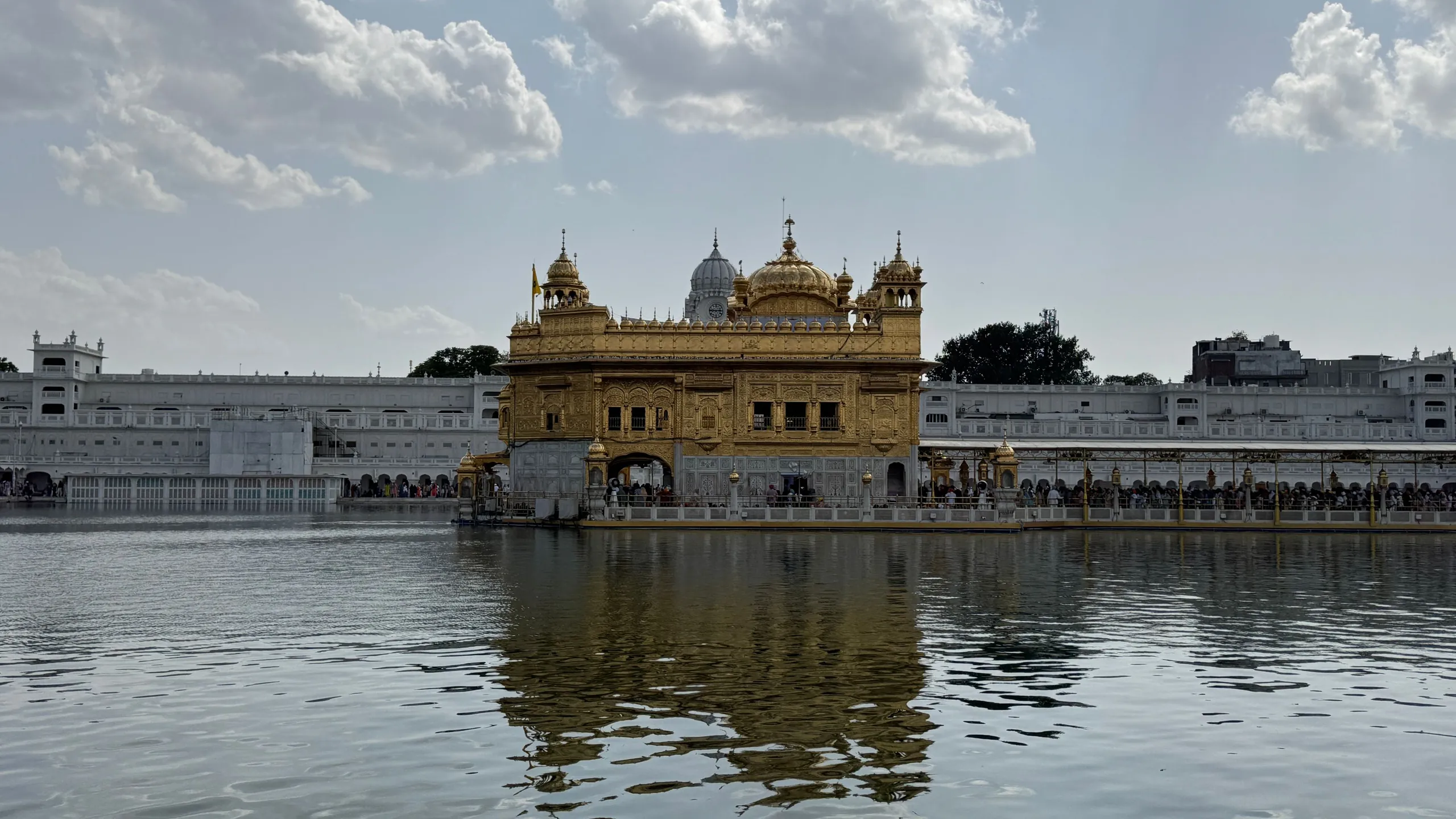 The Golden Temple at Amritsar across its pool, clouds above