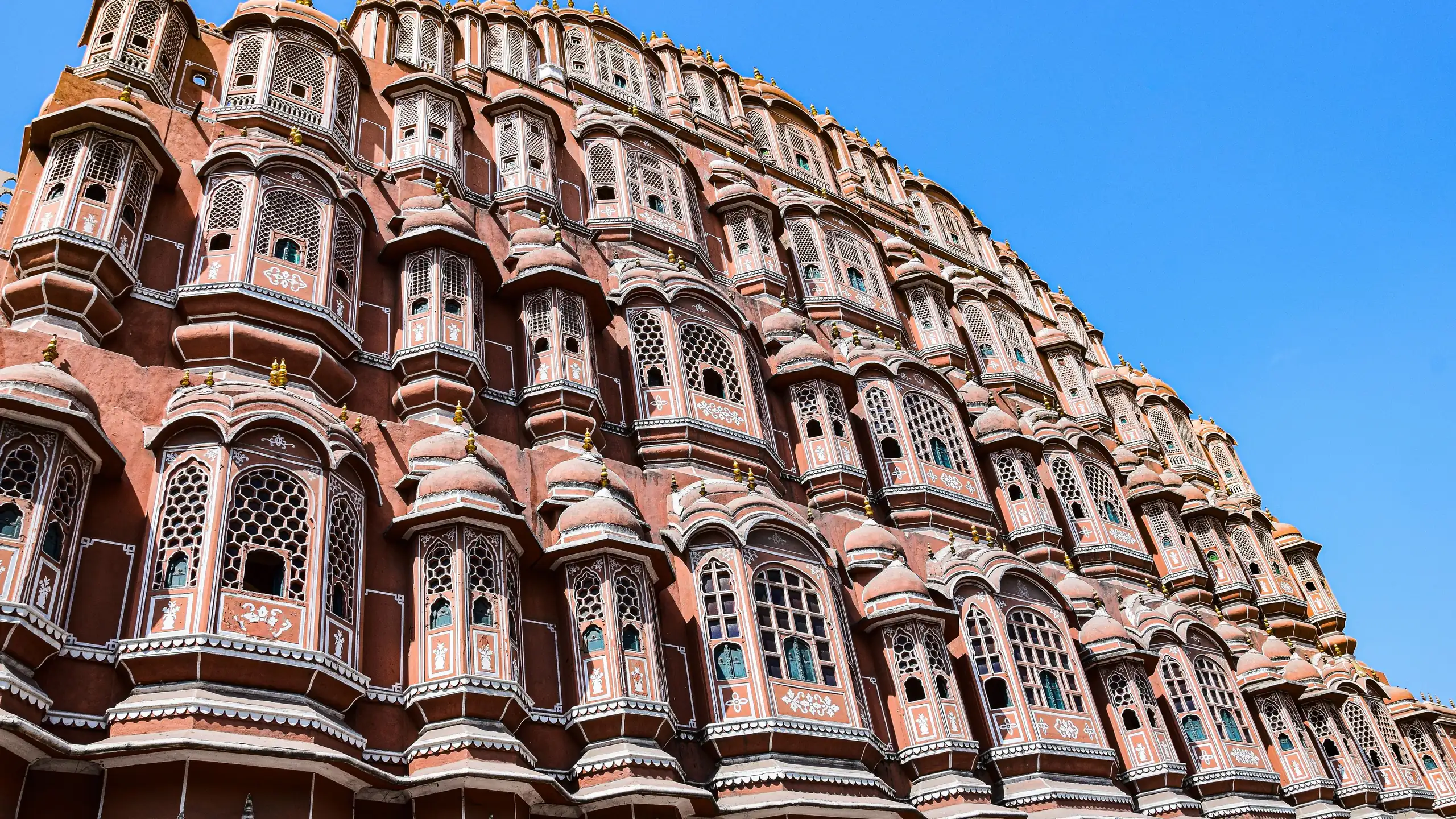 The facade of Hawa Mahal in Jaipur against a blue sky