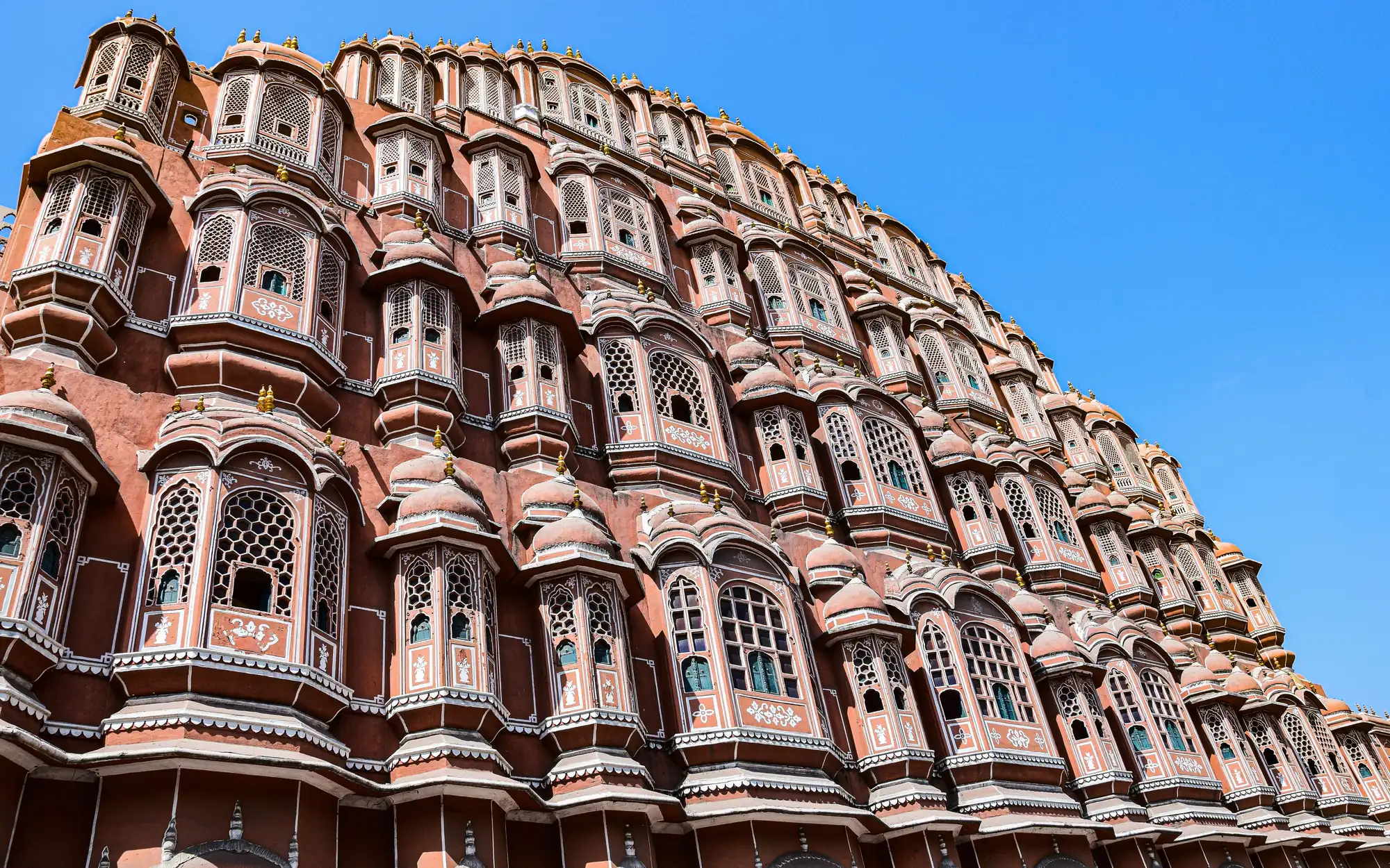 The facade of Hawa Mahal in Jaipur against a blue sky